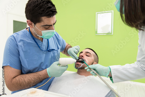 Dentist Curing A Male Patient