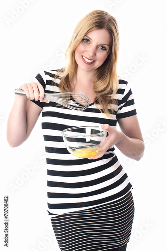 Model Released. Young Woman Mixing Eggs
