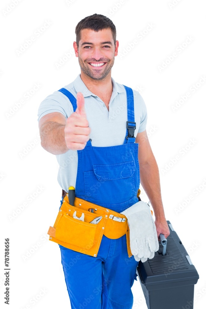 Fotografie Happy repairman with toolbox gesturing thumbs up