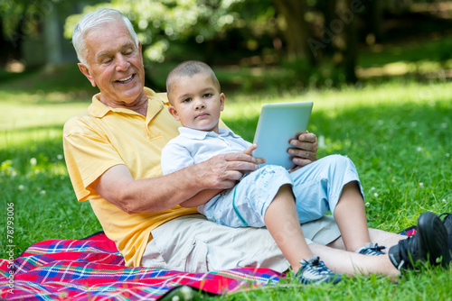grandfather and child in park using tablet © .shock