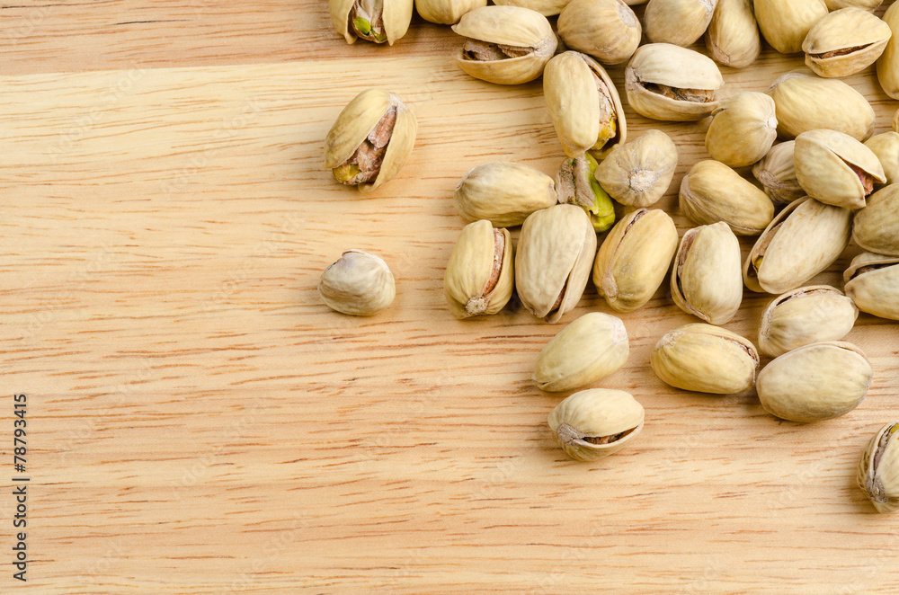 roasted and salted pistachios on wooden background roasted and salted pistachios on wooden background