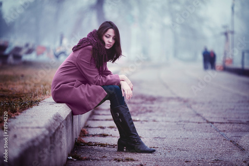 Schilderij op canvas Sad Young Woman Sitting Outdoors