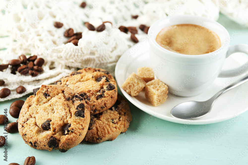 Cup of coffee and tasty cookie on color wooden background Cup of coffee and tasty cookie on color wooden background