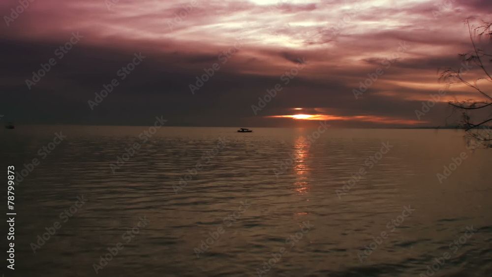 Small Indonesian boat in the ocean under reddish sunset Small Indonesian boat in the ocean under reddish sunset