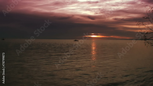 Small Indonesian boat in the ocean under reddish sunset