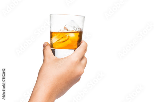 Hand toasting a glass of whiskey on the rocks