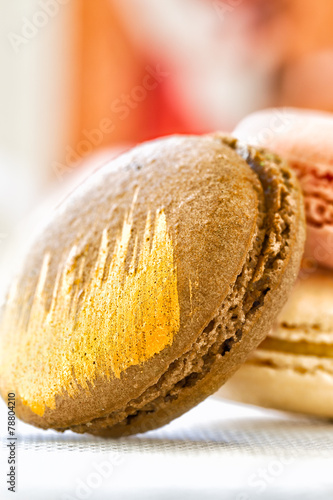 Macaroon decorated with edible gold paint. Close up with selecti photo