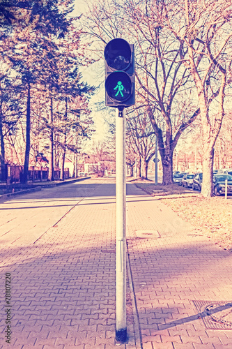 Retro filtered photo of traffic lights, green displayed.