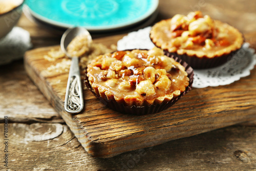 Mini cakes with nuts on wooden background