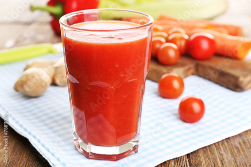 Glass of tomato juice with vegetables on wooden table close up