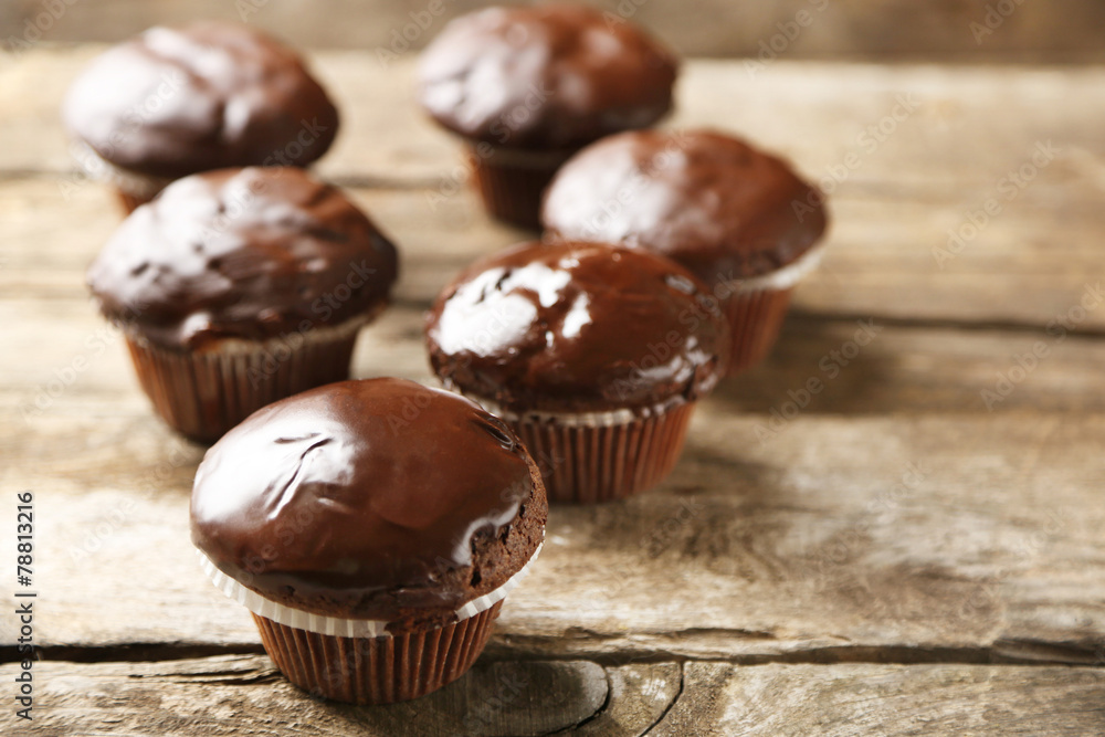 Tasty homemade chocolate muffins on wooden table Tasty homemade chocolate muffins on wooden table