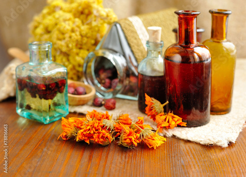 Healing herbs and tinctures in bottles on sackcloth