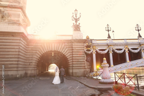 Photography Bride and groom in the sunlight near a bridge