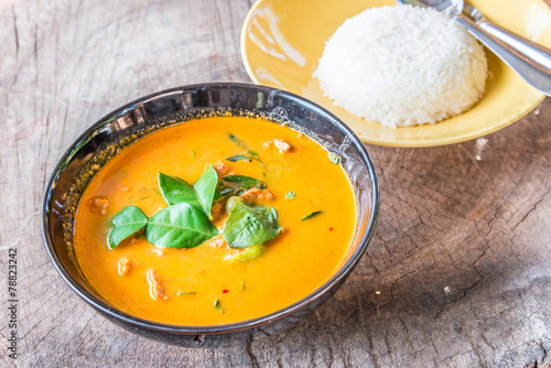 Delicious Thai panang curry and rice on wood background.