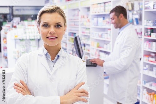 Smiling pharmacist standing with arms crossed