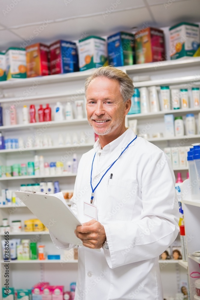 Senior pharmacist writing on clipboard Senior pharmacist writing on clipboard