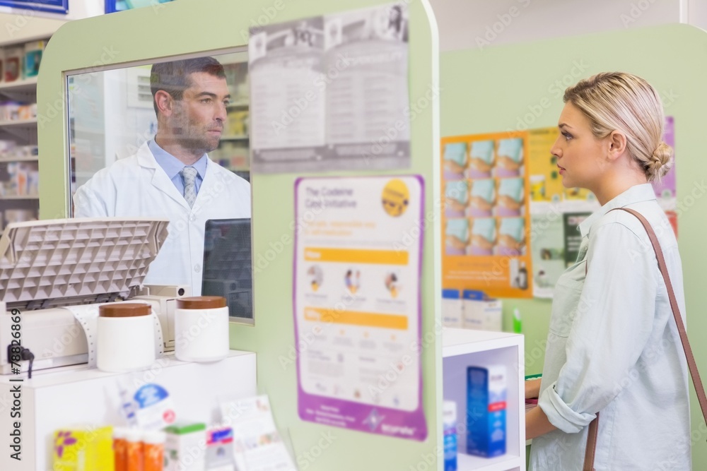 Pharmacist speaking with cheerful young customer Pharmacist speaking with cheerful young customer