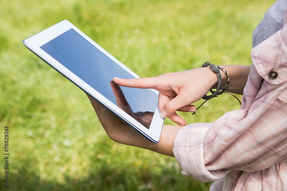 Woman using a tablet in the park