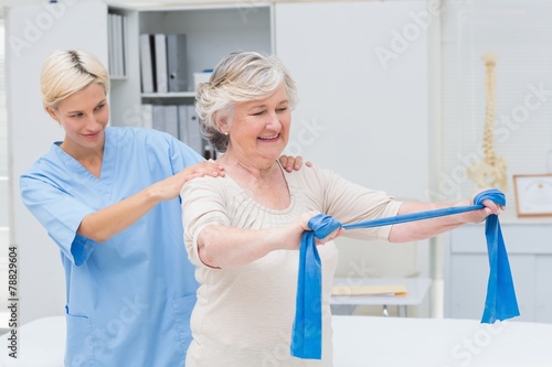 Nurse assisting senior patient in exercising