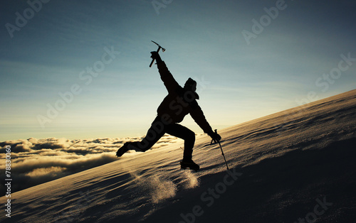 jumping man on a snowy slope in the mountains against sun