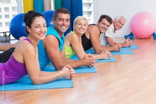 People relaxing on exercise mats in fitness studio