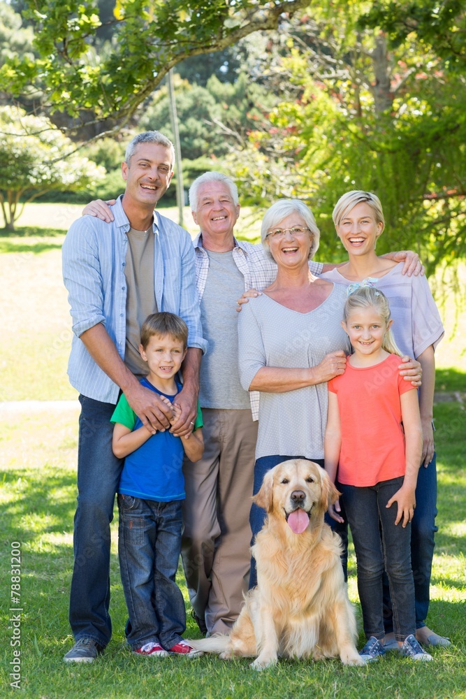 Fototapeta premium Happy family with their dog smiling to camera