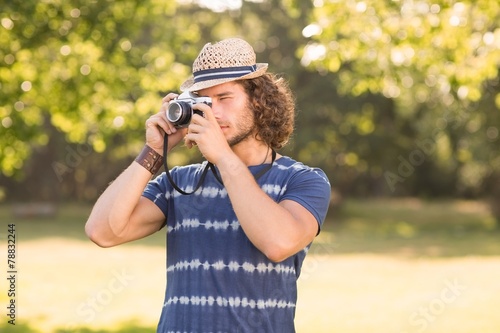 Handsome hipster using vintage camera