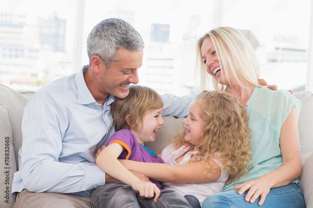 Parents looking at children hugging at home