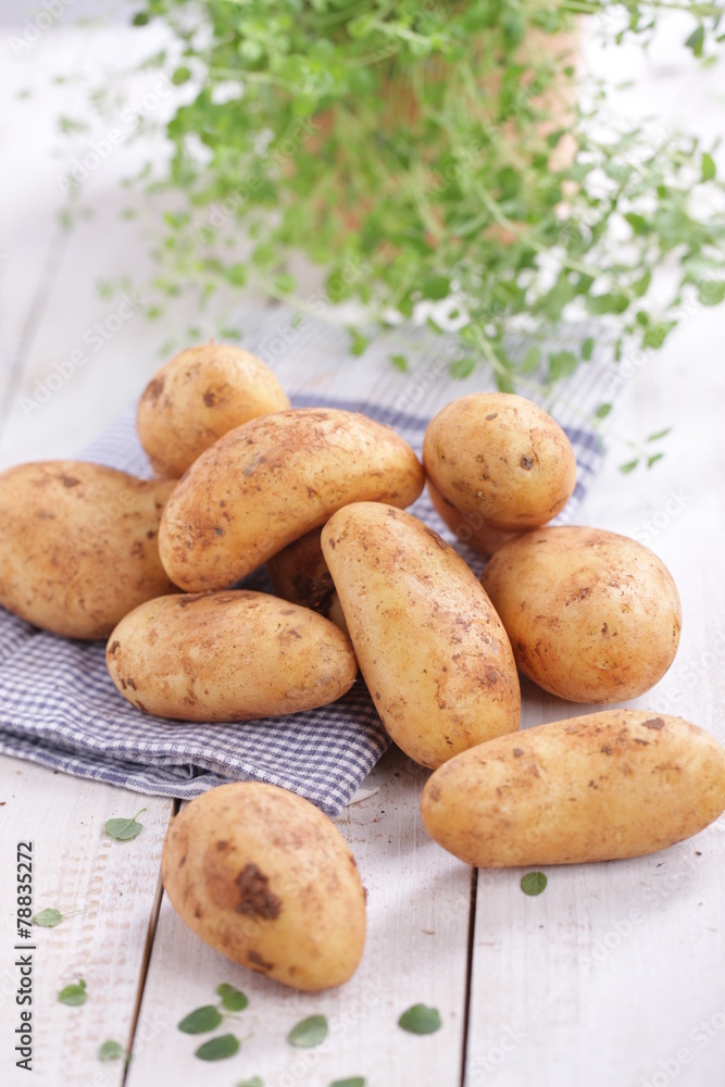 Rohe festkochende Kartoffeln auf Holzbrett Rohe festkochende Kartoffeln auf Holzbrett