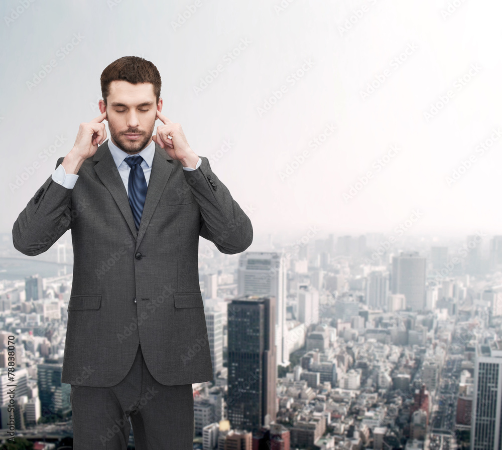 annoyed businessman covering ears with his hands annoyed businessman covering ears with his hands