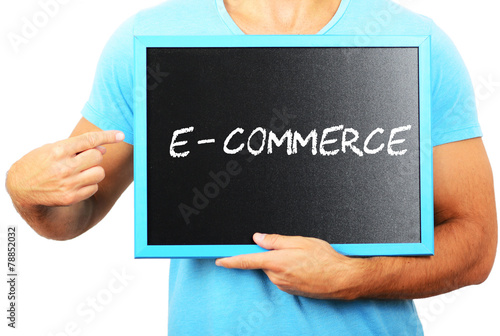 Man holding blackboard in hands and pointing the word E - COMMER