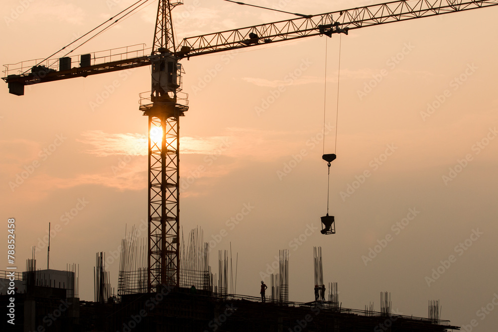 Industrial landscape with silhouettes of cranes on the sunset