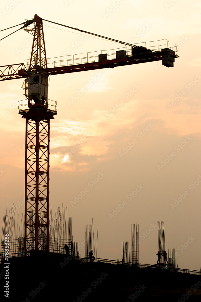 Industrial landscape with silhouettes of cranes on the sunset