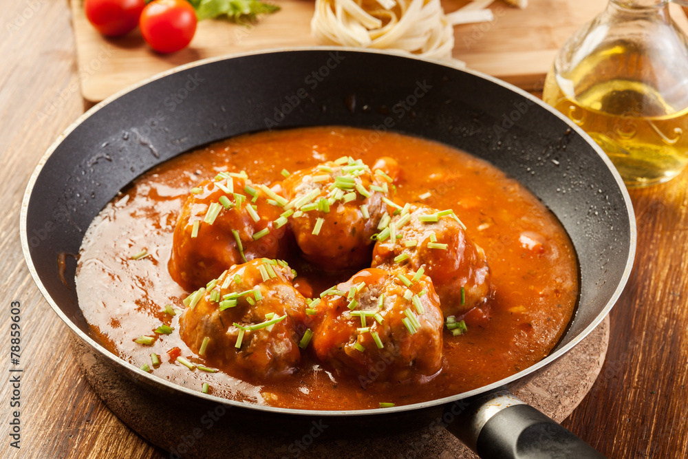 Meatballs with tomato sauce on black pan Meatballs with tomato sauce on black pan