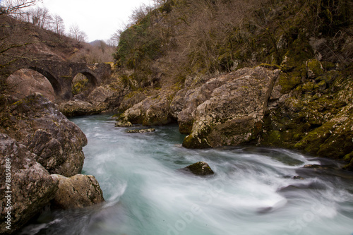 Beautiful turquoise pond and old stone bridge