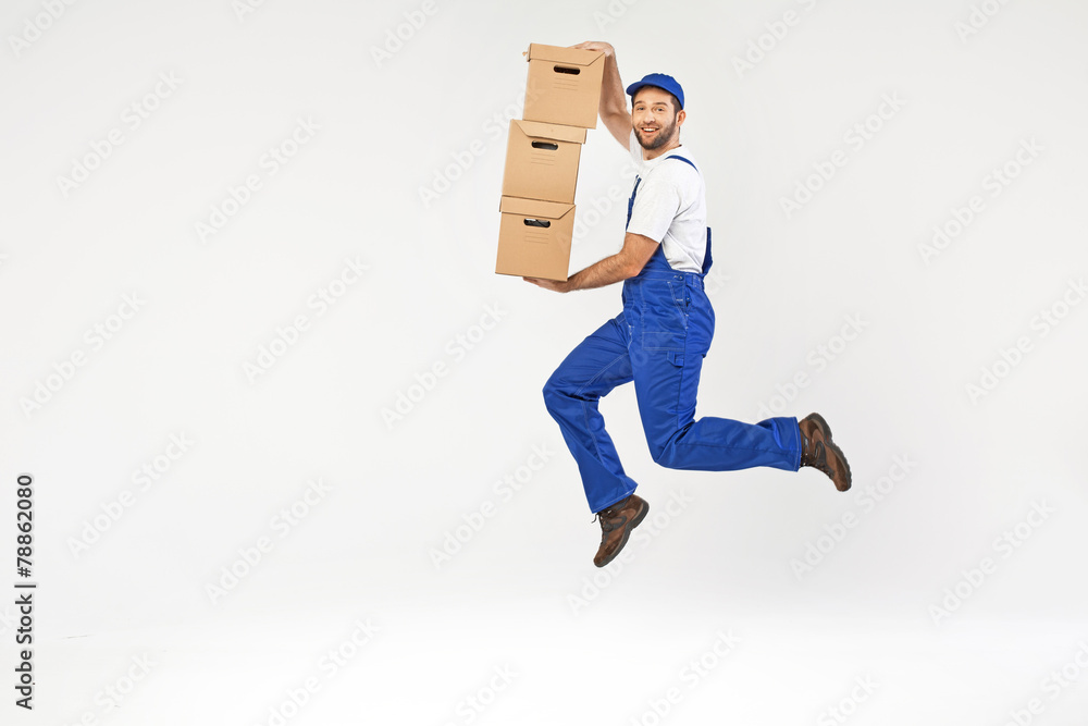 Attractive builder jumping with boxes Attractive builder jumping with boxes