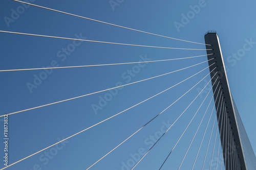 Fragment of a modern cable stayed bridge on the sky background.