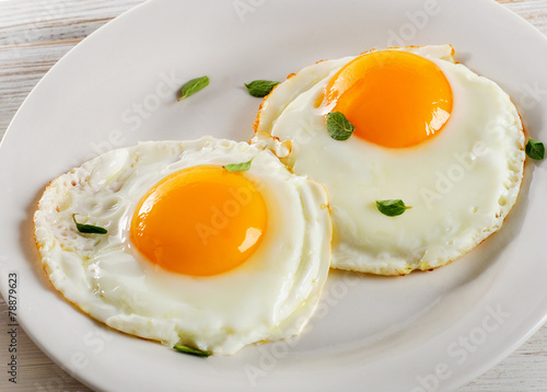 Two fried eggs on white plate for healthy breakfast