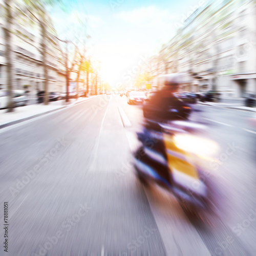 Motorcycle rider on the street in motion blur at sunset. © Elena Volkova
