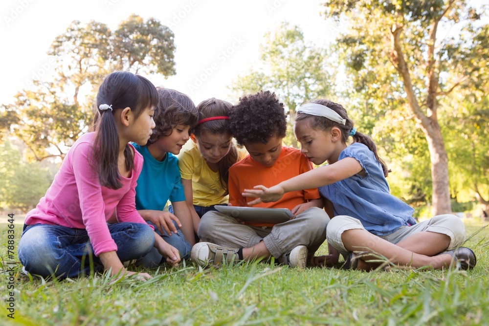 Little children using tablet in park Little children using tablet in park