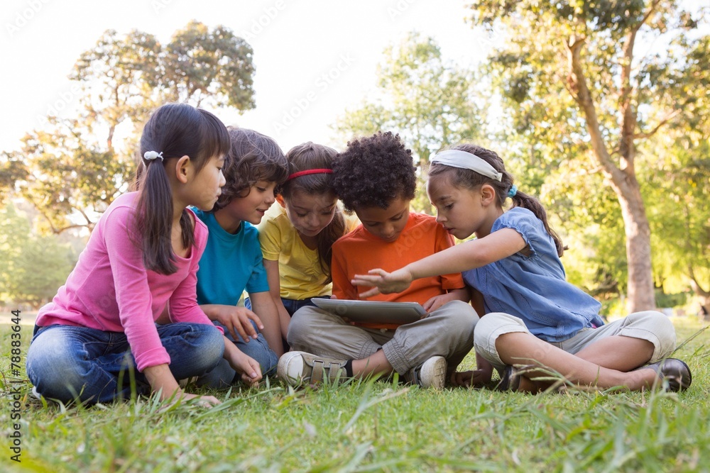 Little children using tablet in park