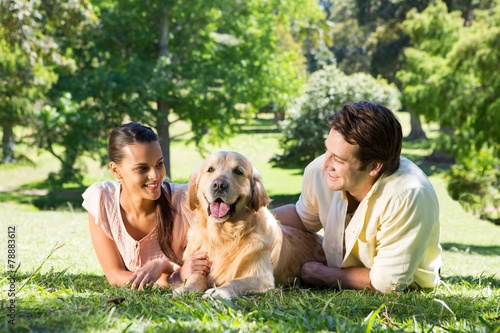 Happy couple with their dog in the park
