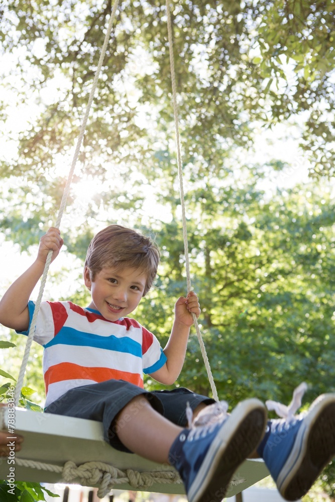 Happy little boy on a swing in the park Happy little boy on a swing in the park