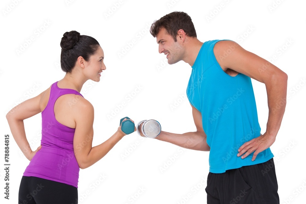 Fit man and woman lifting dumbbells Fit man and woman lifting dumbbells