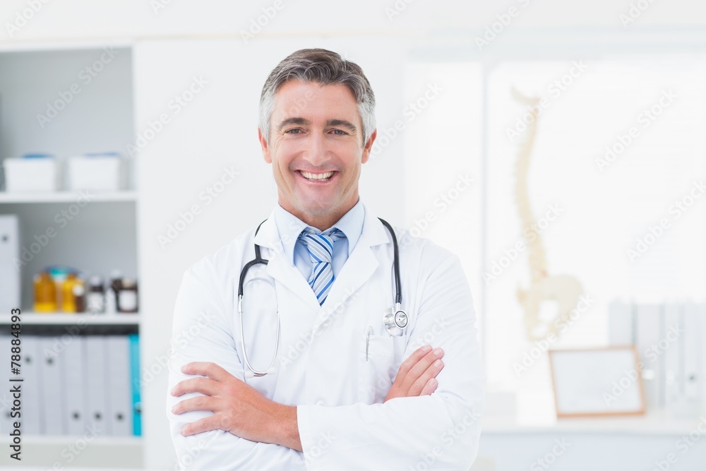 Confident doctor with arms crossed standing in clinic Confident doctor with arms crossed standing in clinic