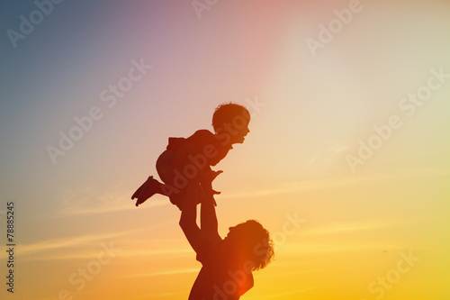 father and son silhouettes play at sunset © nadezhda1906