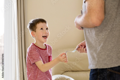Boy receiving pocket money (allowance) from father