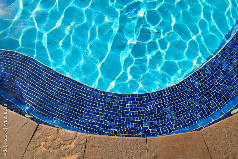 Blue tiles in the Swimming pool and sunlight reflection