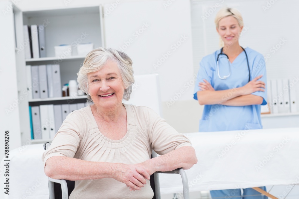 Obraz premium Senior patient sitting on wheelchair while nurse standing