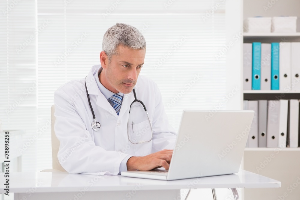 Serious doctor using laptop Serious doctor using laptop